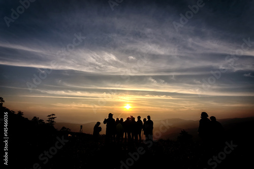 Silhouette of photographers on top of mountain seeing sunrise in the morning, Phu Lom Lo, Loei, Thailand.