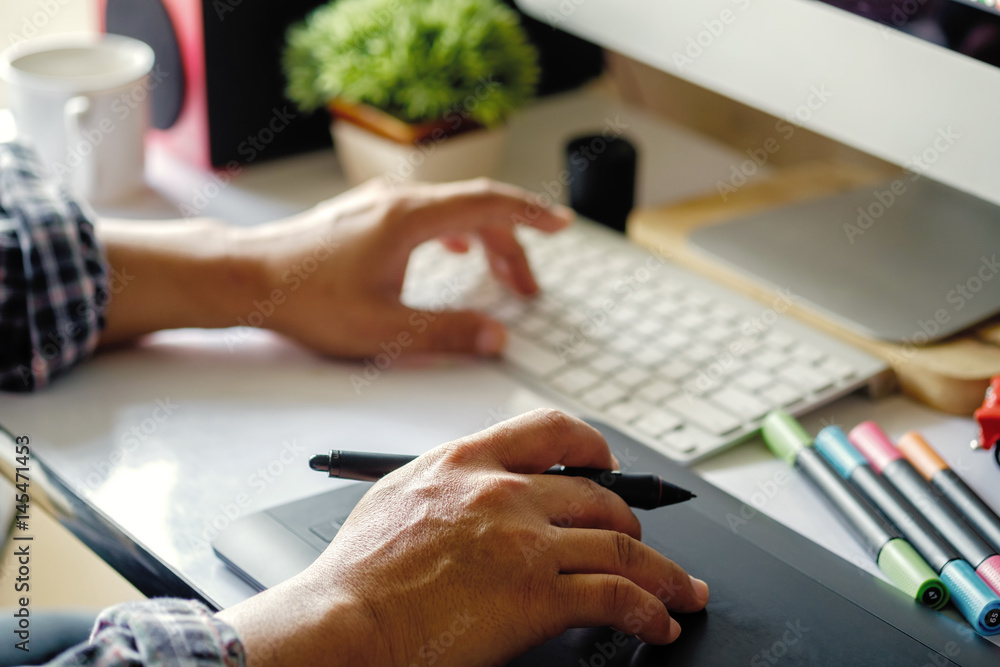 Man or Designer working on digital tablet with Designer stuff on White Desk. Graphic Designer workplace. Man or Designer working on digital tablet with Designer stuff on White Desk. Graphic Designer workplace.