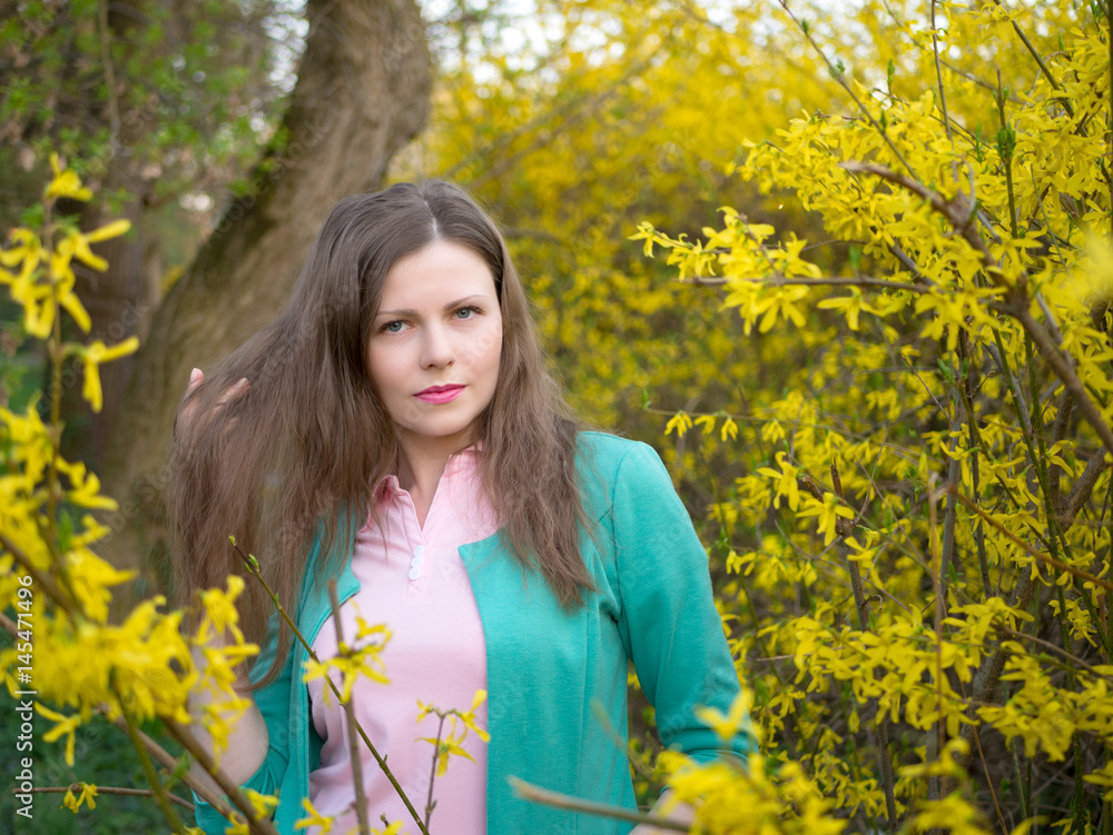 outdoor portrait beautiful girl in green jacket among yellow blossom tree outdoor portrait beautiful girl in green jacket among yellow blossom tree