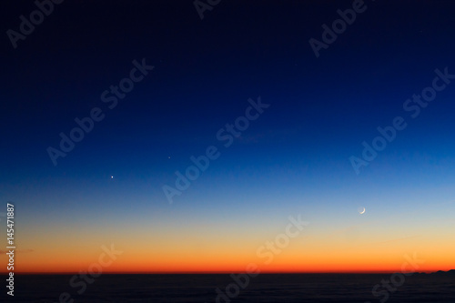 Mountain silhouette over clouds,sky at twilight with moon