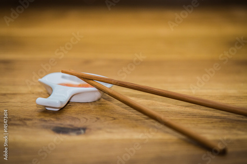 Wood chopsticks on table set for dinner photo