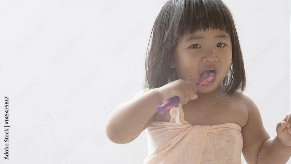 Asian baby girl is brushing teeth in the morning with a white background. Asian baby girl is brushing teeth in the morning with a white background.