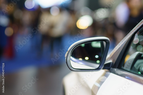 Soft focus back side view of rear view mirror of luxurious car with blurred background. ,Selective focus at left border of rear view mirror ,Copy space for insert text.
