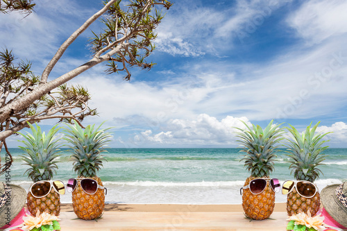 pineapple with sunglasses and hat beach on wood,concept summer background.