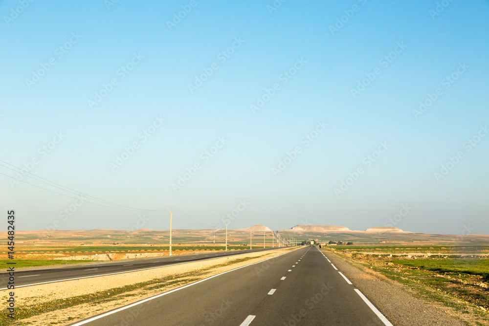 Very long straight highway in Morocco with low horizon
