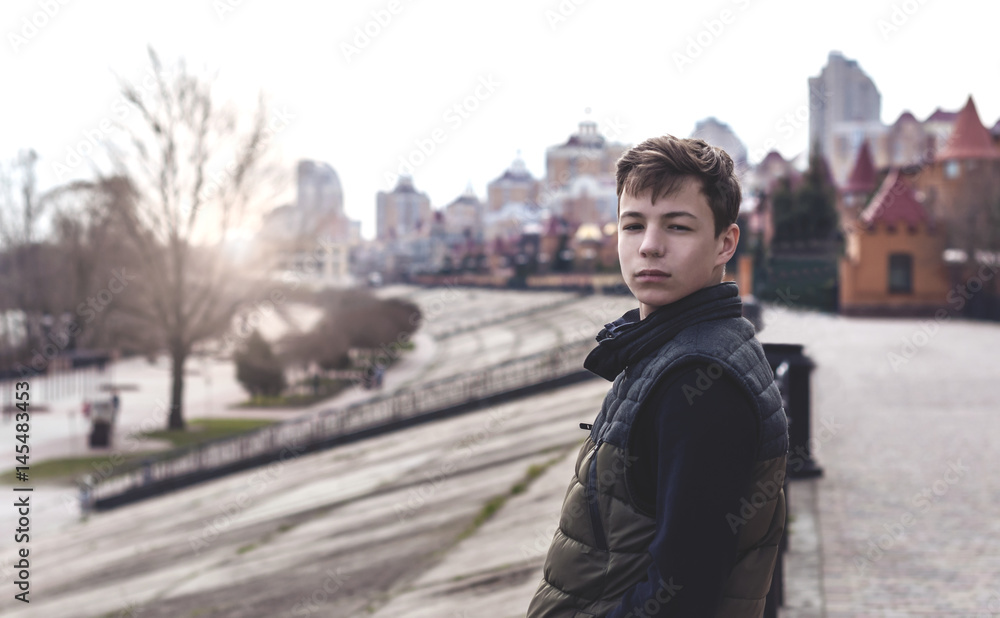 Sad young man standing on a city street Sad young man standing on a city street