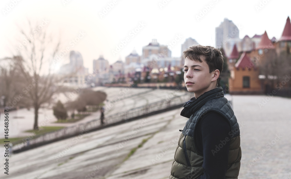 Sad young man standing on a city street