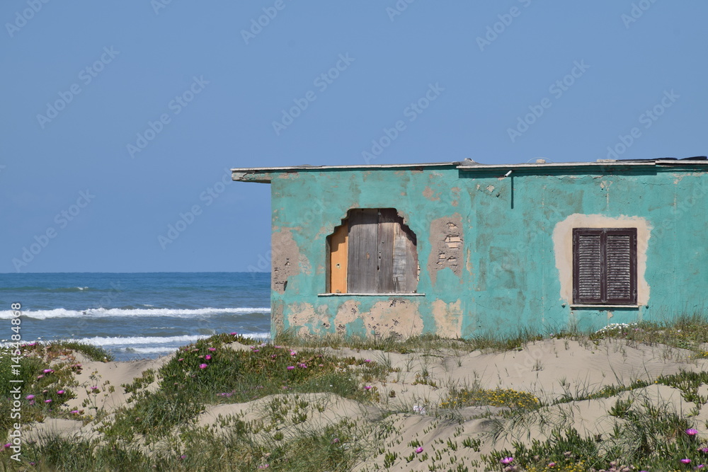 Green shack in front of the sea Green shack in front of the sea