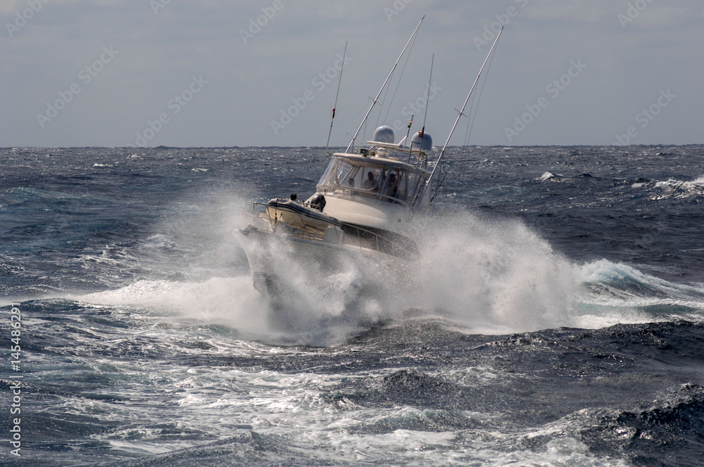 Fototapeta premium Sports Fishing Boat returns to anchorage in rough seas