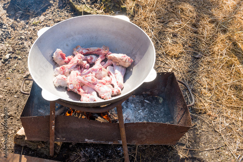 The recipe for cooking soup from mutton - shurpa in a cauldron in the fresh air.