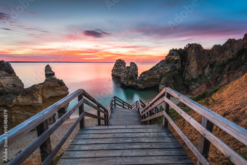 Wooden footbridge walkway to beautiful beach Praia do Camilo on coast of Algarve region, Portugal