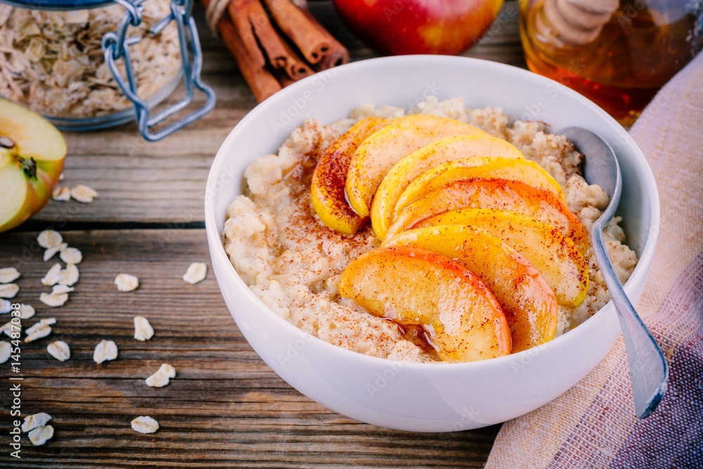 Healthy breakfast: oatmeal bowl with caramelized apples, cinnamon and honey
