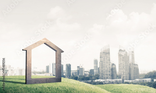 Conceptual image of concrete home sign on hill and natural lands