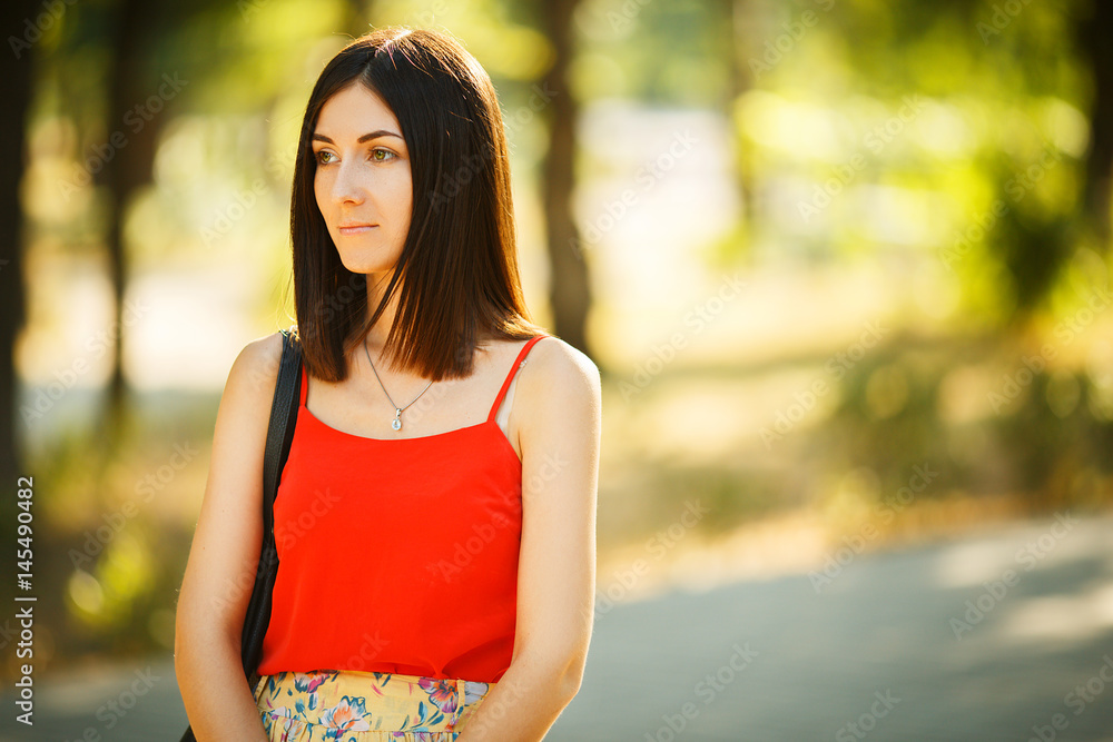 Beautiful woman in red blouse walks in the park Beautiful woman in red blouse walks in the park