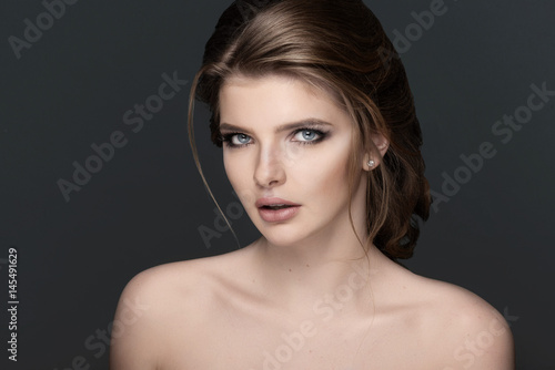 Studio portrait of a beautiful young woman with brown hair.