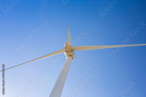 Wind turbine generating electricity with blue sky - energy conservation concept © satura_