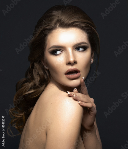 Studio portrait of a beautiful young woman with brown hair.
