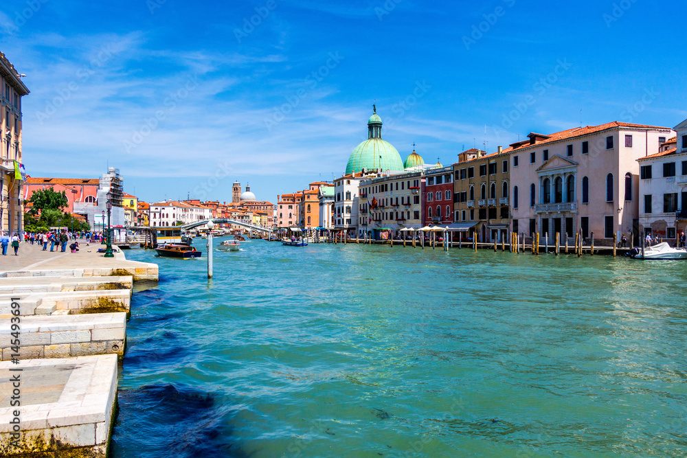 View of the canal with boats and gondolas in Venice, Italy. Venice is a popular tourist destination of Europe