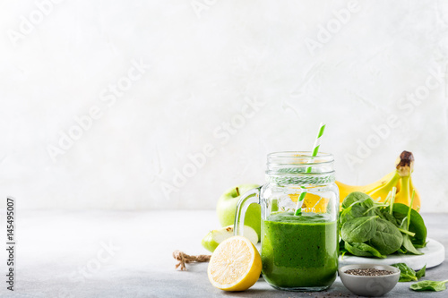 Healthy breakfast with green smoothie in glass jar and ingredients. Detox, diet, healthy, vegetarian food concept with copy space.