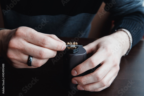 male master installs a coyle. Spiral for electronic evaporator and cigarette. Vape, vaping