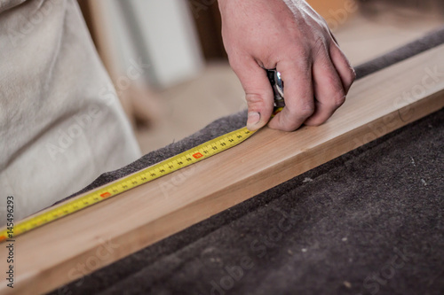 carpenter painting a line for cutting wood