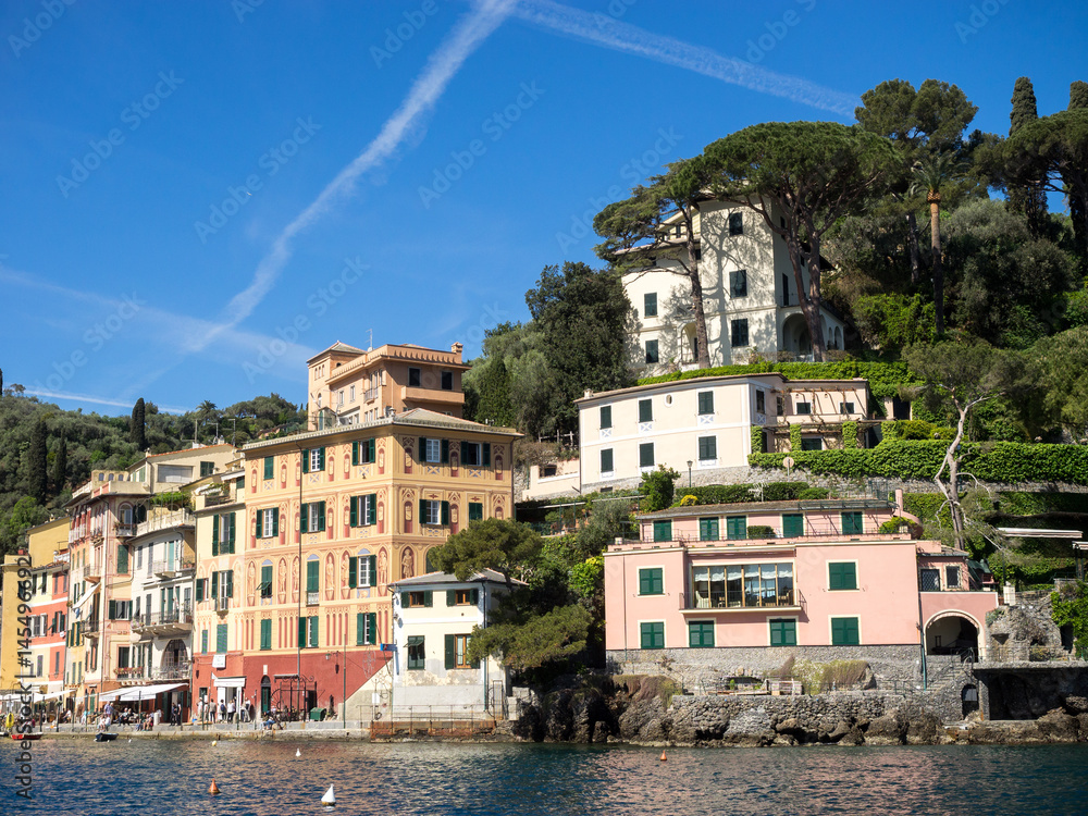 häuserzeile am Hafen von Portofino unter blauem Himmel bei Sonnenschein, Ligurien, Italien
