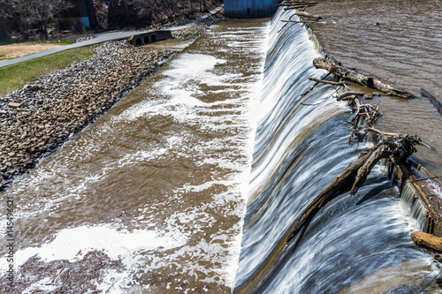 Small dam with running water fall in Accotink park in Fairfax, Virginia photo