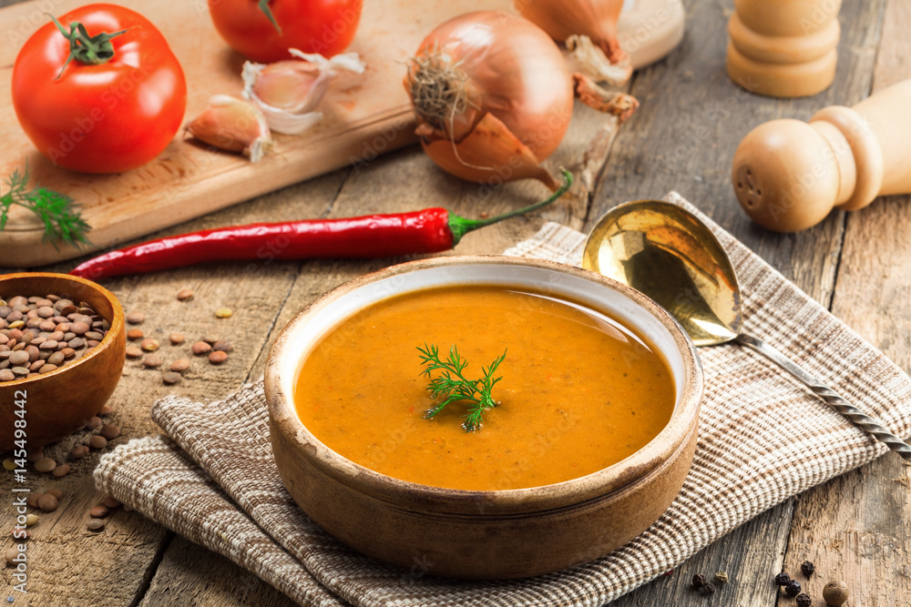 Lentil soup in a rustic bowl on a cotton canvas tablecloth. Healthy vegetarian food on an old wooden table. Top view. Lentil soup in a rustic bowl on a cotton canvas tablecloth. Healthy vegetarian food on an old wooden table. Top view.