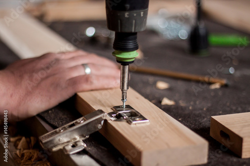 Close op picture of hands working with drill on wood