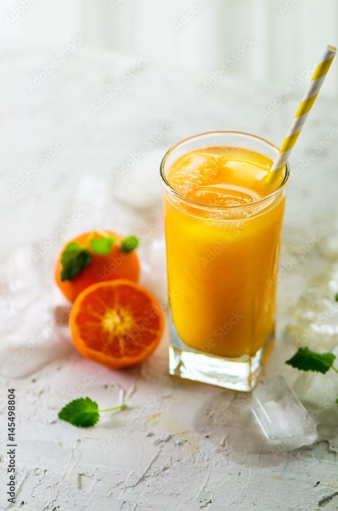Orange juice with ice and tangerines on white background. Free space for your text. Copyspace. Cold beverage for hot summer day. Orange juice with ice and tangerines on white background. Free space for your text. Copyspace. Cold beverage for hot summer day.