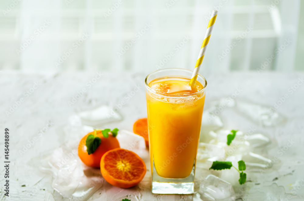 Orange juice with ice and tangerines on white background. Free space for your text. Copyspace. Cold beverage for hot summer day. Orange juice with ice and tangerines on white background. Free space for your text. Copyspace. Cold beverage for hot summer day.