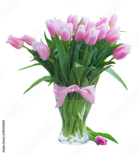 Bouquet of fresh pink tulips with green leaves in vase isolated on white background