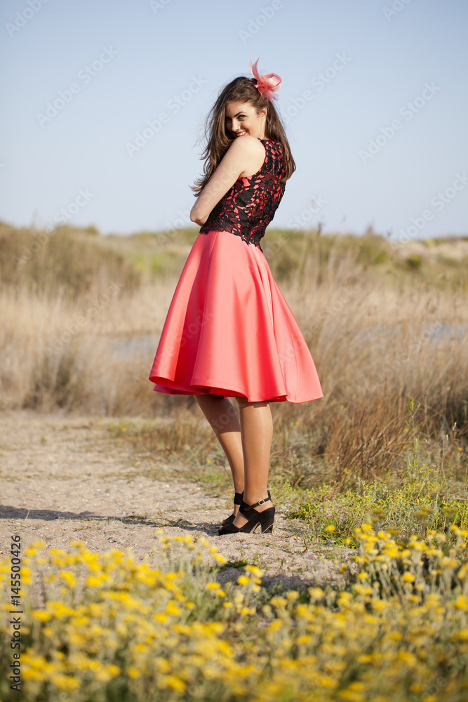 Mujer con vestido rojo en el campo foto de Stock | Adobe Stock