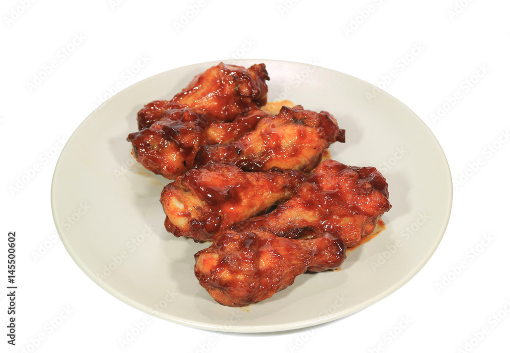 Grilled chicken wing sticks served on a white plate Grilled chicken wing sticks served on a white plate