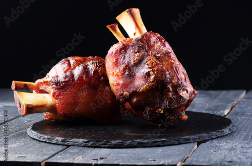Photography Smoked ham hock with herbs and spices on wooden plate.