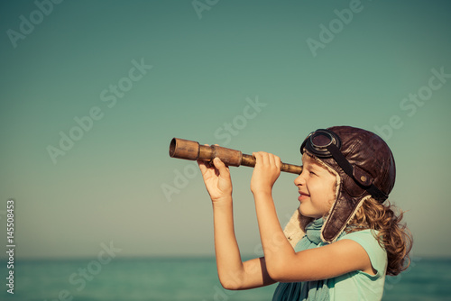 Happy kid playing outdoor against sea and sky Fototapeta