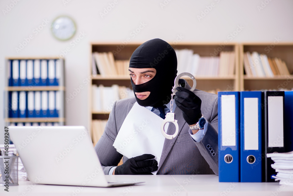 Criminal businessman with balaclava in office Criminal businessman with balaclava in office