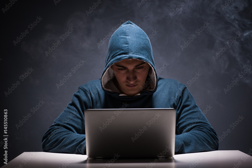 Computer hacker working in dark room Computer hacker working in dark room