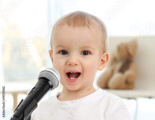 Cute baby with microphone a...