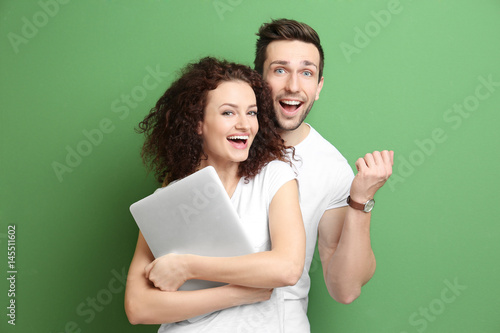 Happy young couple with lap...