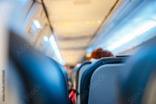 Interior of airplane with passengers on seats, shallow DOF