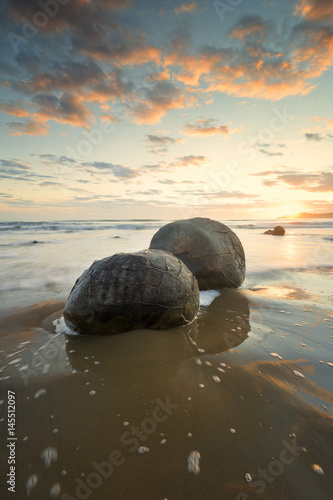 Moeraki boulders during sunrise with beautiful colors.