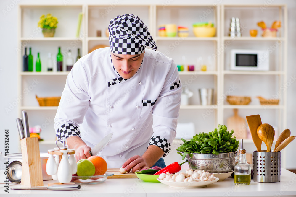 Young male cook working in the kitchen Young male cook working in the kitchen
