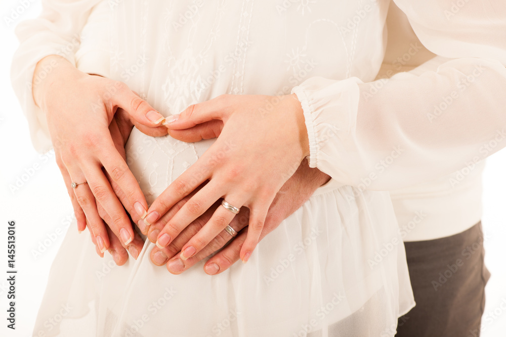 Man and pregnant woman holding hands on belly Man and pregnant woman holding hands on belly