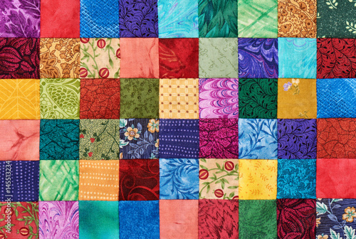 Colorful detail of quilt sewn from square pieces photo