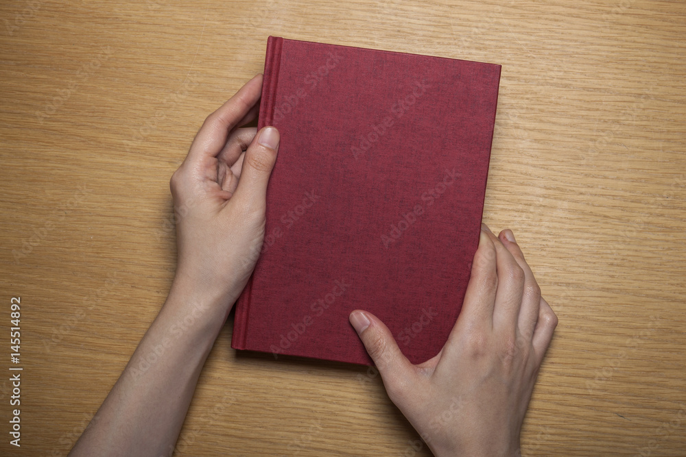 woman hand hold a paper on the wood background(desk, table) woman hand hold a paper on the wood background(desk, table)