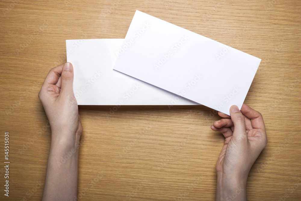 woman hand hold a letter with envelope on the wood table. woman hand hold a letter with envelope on the wood table.