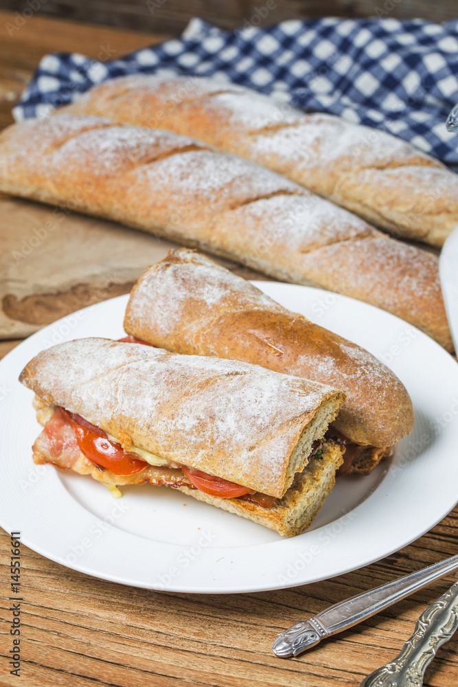 open sandwich with prosciutto, mozzarella and tomatoes on kitchen table, shallow focus open sandwich with prosciutto, mozzarella and tomatoes on kitchen table, shallow focus