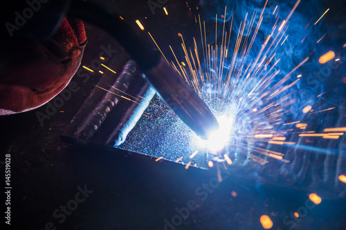 the welding spark light in close-up scene,the torch of welging machine with the spark light in blue