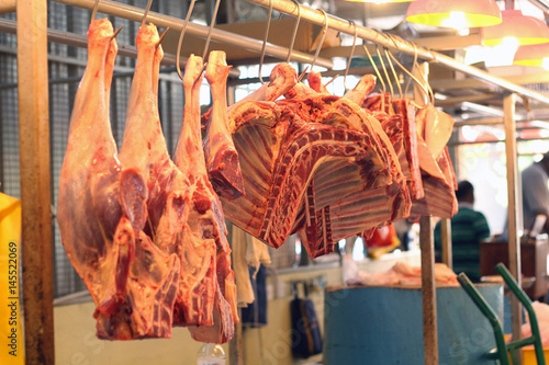 Meat ribs muttons hang on the counter market for sale. Chopped meat ribs lie on the counter. Freshly cut cow carcass half showing the ribs and spine, hanging on a butcher